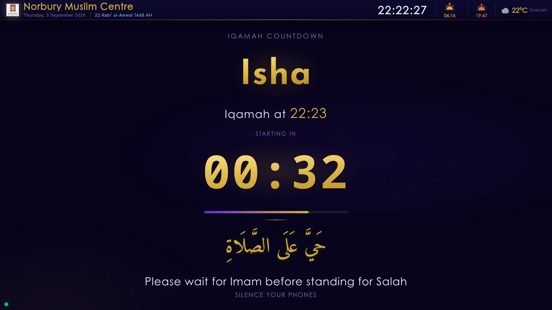 Signage displaying the Iqamah countdown for Isha with 'Hayya alas-salah' and a silence reminder